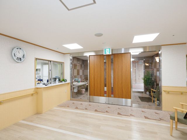 ゆったりした通路と受付 受付 広々としたエントランスには、来訪者をやさしく迎える受付カウンターがあり、明るく落ち着いた雰囲気が感じられます。