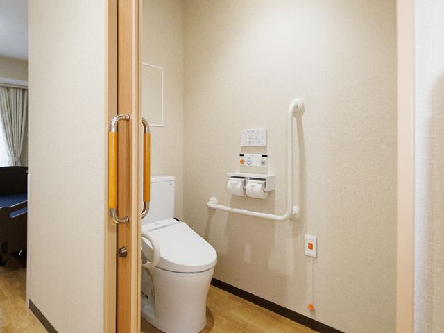 バリアフリーな洋室トイレ トイレ 椅子付きの暖房便座や手すり完備の清潔なトイレ空間です。スタッフと快適な職場環境での仕事を志望される方におすすめです。