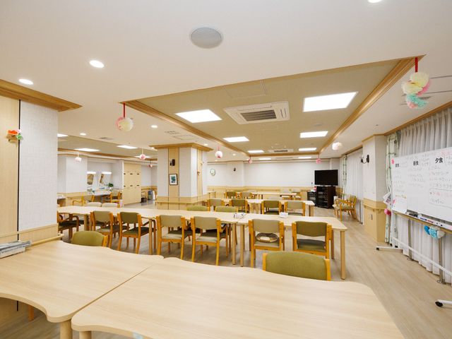 和やかな食堂の光景 共有スペース 明るく開放的な食堂で、共に食事を楽しむ時間を大切にしています。職員とのコミュニケーションも活発に行われる空間です。