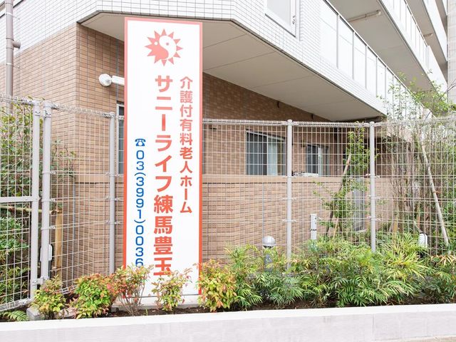 施設看板と外観 外観   建物の前に看板が立つ外観です。周囲には植栽があり、落ち着いた印象です。