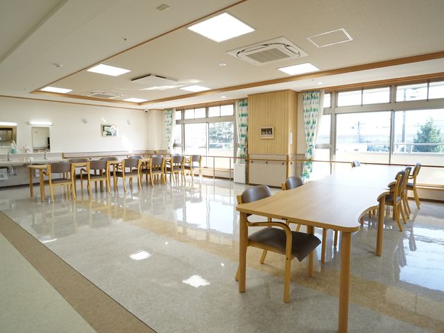 広々とした明るい食堂 共有スペース 天井が高く、自然光が差し込む広々とした食堂で、ゆったりとした食事の時間を過ごせます。機能的な設計のイスやテーブルも配慮されており、穏やかな雰囲気が漂っています。