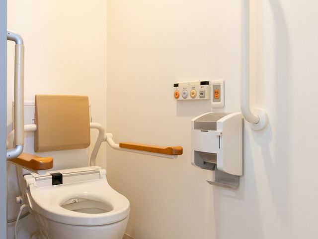 手すり完備の綺麗なトイレ トイレ 清掃がしやすく、安全な手すりが設置されたトイレで、利用者のサポートを行います。