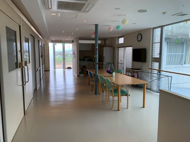 広々とした廊下 廊下 開放的な空間で、自然光が差し込む明るい廊下です。ゆったりとした机と椅子があります。