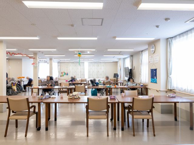 車椅子利用者のいる食堂 食堂   明るい採光のある広い食堂です。車椅子の方も過ごしやすい、ゆとりあるテーブル配置になっています。