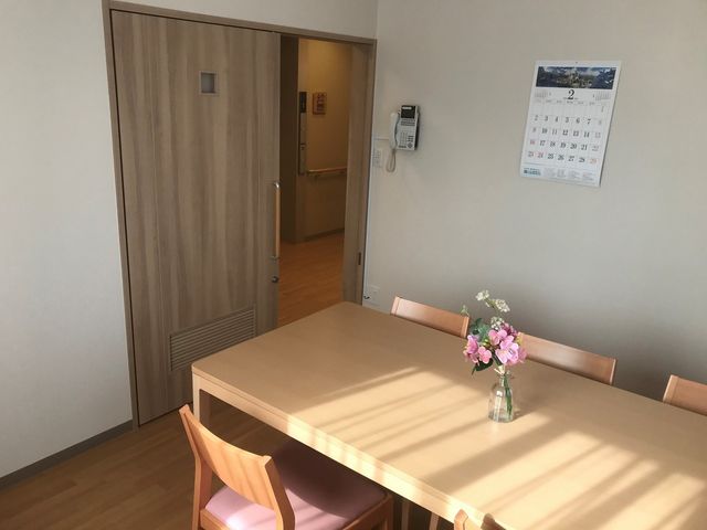 快適な居室の一角 ファミリールーム 明るい日差しが差し込む居室には、家庭的な雰囲気を持つダイニングテーブルが設置され、心地よい毎日を過ごせるよう配慮しています。