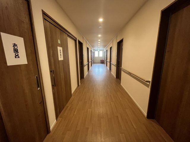 手すり付きの廊下風景 廊下 清掃が行き届いた廊下が印象的な職場で、利用者の方々の安全を守るお手伝いをしませんか。