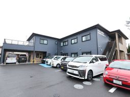 グレーの建物外観と駐車場