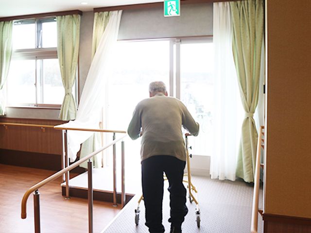 車椅子利用の人の様子廊下 廊下   大きな窓から自然光が降り注ぐリラックスできる空間です。手すりがあり、移動も安心です。