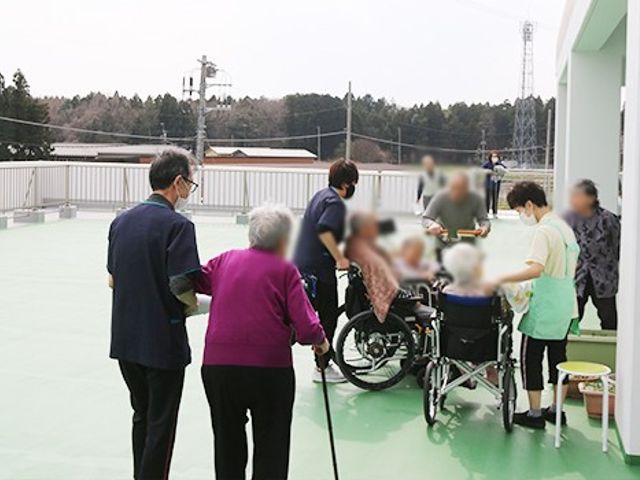 戸外で過ごす様子 テラス 広いテラスで皆が談笑して過ごしています。リラックスしたひとときを楽しめます。