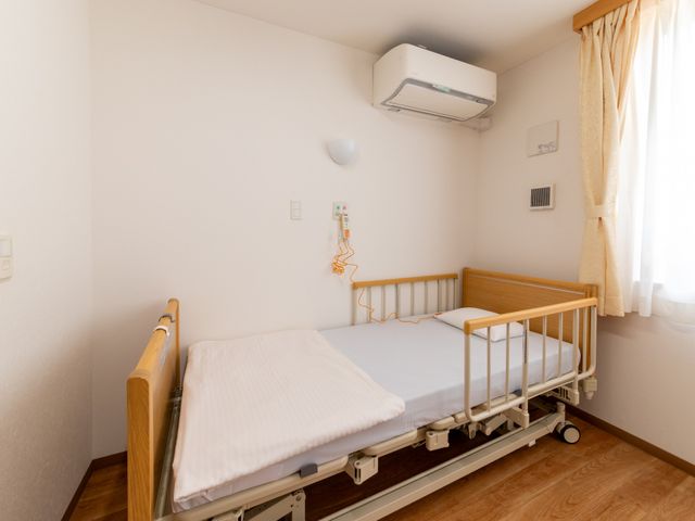 明るい居室のベッド 居室   自然光が入る明るい居室です。電動ベッドが設置され、落ち着いて休める空間になっています。