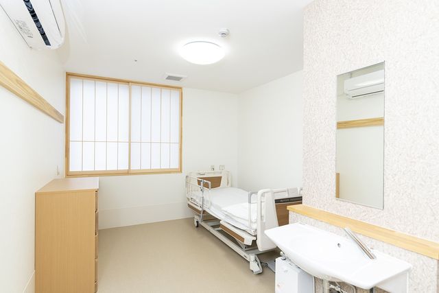 シンプルな居室 居室 ベッドと洗面台が備えられた居室です。窓から自然の光が差し込み、落ち着いた空間を演出しています。