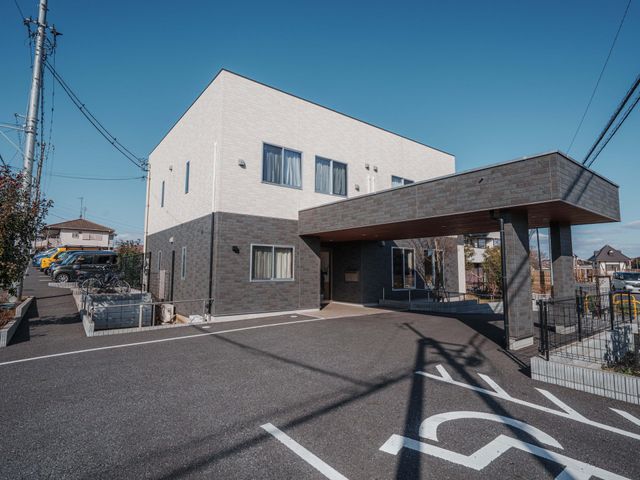 広々とした建物の外観 外観 青空の下、広い駐車スペースを備えた建物です。洗練されたデザインが特徴です。