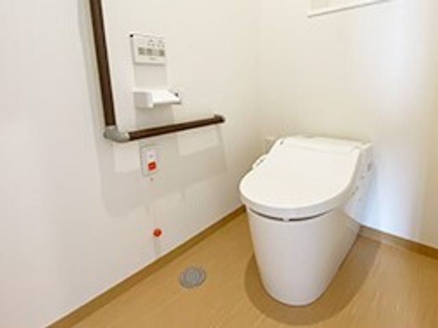バリアフリー設計のトイレ トイレ 安全に配慮された手すり付きの清潔なトイレです。ゆとりあるスペースで快適な利用が可能です。