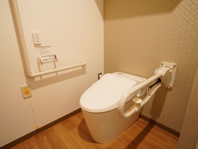 バリアフリーなトイレ空間 トイレ 手すり付きのモダンなトイレで、安全かつ快適にご利用いただける環境を整えています。