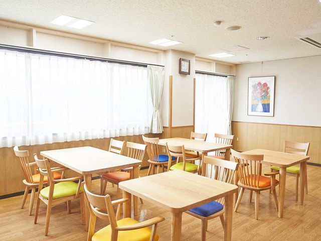 安らぎの食堂空間 ダイニングルーム 明るく清潔感のあるダイニングで、お食事や会話をお楽しみいただけます。色とりどりの椅子が彩りを加えています。