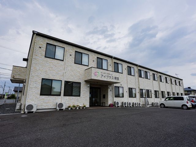 石造り外観の建物 外観   落ち着いた色合いの外壁と大きな窓が印象的な建物です。駐車スペースも見えて、出入りしやすい雰囲気です。