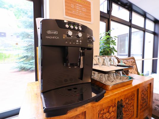 一面窓の壁際に置かれた黒いコーヒーメーカー