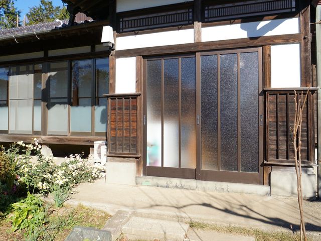和風の建物の入口 玄関 落ち着きのある和風の入口が迎える、明るく穏やかな雰囲気の場所です。自然に囲まれた環境で、ゆったりとした時間を過ごせます。