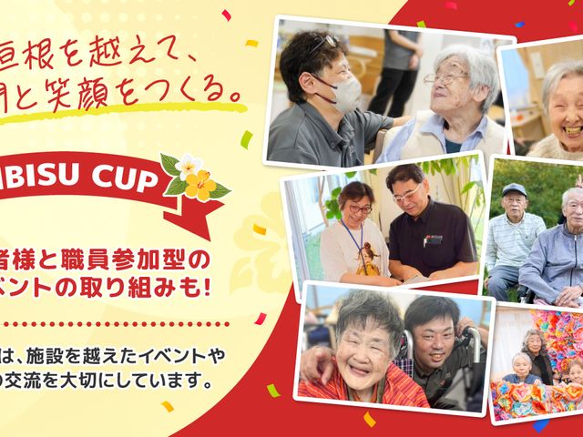 職員と笑顔の利用者たち スタッフイメージ   職員が利用者の方と会話や記念撮影をしており、明るい雰囲気が伝わります。イベントを通じて交流を深める様子が見られます。