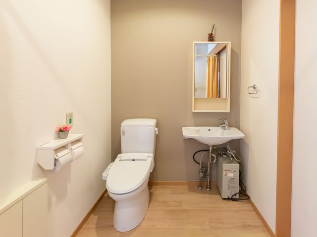 清潔感のあるトイレ空間 トイレ 手すりと広々とした造りで、ご高齢の方も使いやすいトイレ環境が整っています。快適さと安全が考慮された設計です。