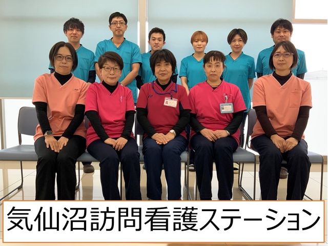 スタッフ集合の看板 看板   明るい空間で、看護や介護に携わるスタッフの皆さんが並んでいます。施設名の看板も写っており、働く雰囲気を感じやすいです。