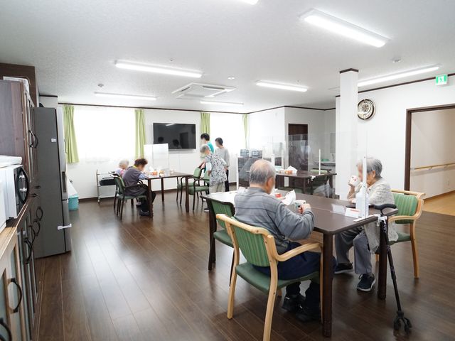 共有スペースでの食事風景 共有スペース 明るく広々としたダイニングで、入居者の方々が食事を楽しまれています。安心して働ける環境です。