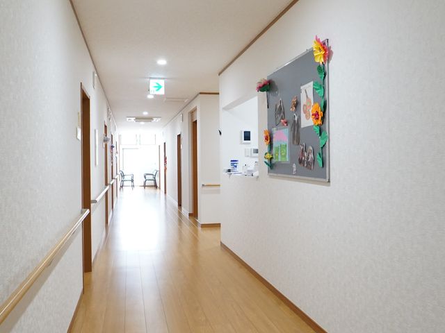 掲示物がある明るい廊下 廊下 手すりが備え付けられた廊下は清潔感があり、壁には季節感あふれる装飾が施されています。通路も広く、快適にお仕事ができる環境です。