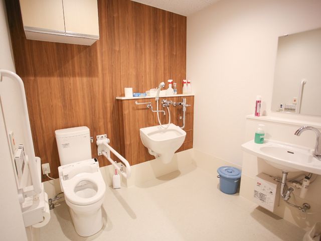 バリアフリー対応のトイレ トイレ 安心してご利用いただける、手すり付きの広々とした清潔なトイレです。明るく、快適な空間を提供しています。