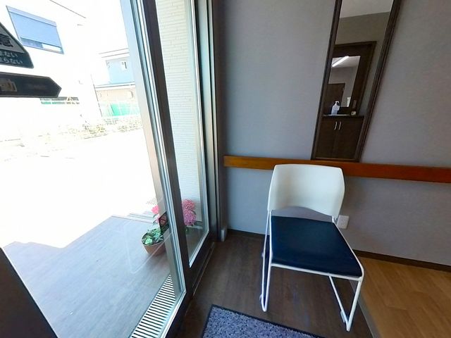 明るい居室の一角 エントランス 広々とした明るい居室の一角です。窓辺には心地よい陽光が差し込み、植物が置かれています。