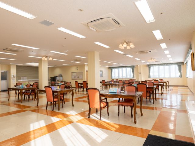 広々とした明るい食堂 共有スペース 床のチェック柄が印象的な広々とした食堂は、コミュニケーションを楽しむ場としても最適です。天井の明るい照明が、明るく開放的な雰囲気を演出しています。
