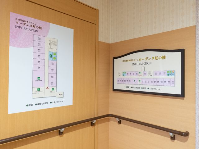 案内板とハンドレールの廊下 展示物 見やすい案内板が設置された廊下は、利用者の方の移動をしっかりサポートします。ハンドレールが安全な歩行を助け、安心してご利用いただけます。