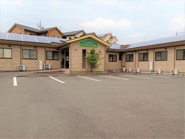 平屋建ての施設外観 外観 ソーラーパネルを設置した建物が、エコにも配慮された環境です。車いすの方も安心の平坦な駐車場が完備されています。