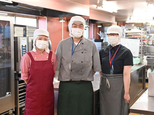 厨房で並ぶ調理スタッフ  