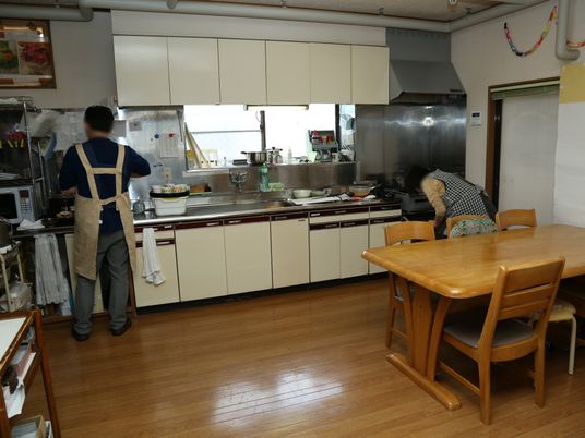 調理中のスタッフとダイニングテーブル
