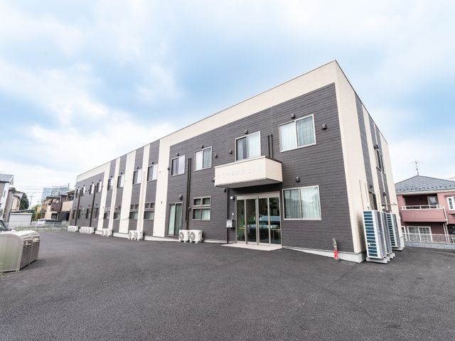 現代的な外観の建物 外観 ゆったりと清潔に保たれた敷地が印象的です。シンプルでモダンなデザインが、新しい職場として期待を膨らませます。