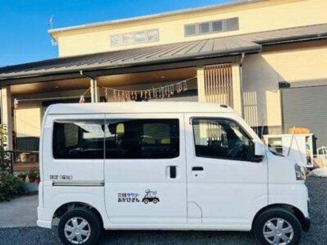 送迎車と建物外観 外観   白い送迎車が建物の前に停まっています。青空の下で、落ち着いた外観の様子が伝わります。
