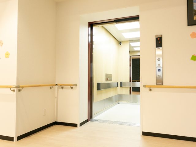 広々とした廊下とエレベーター エレベーター 手すりが設置された安全に配慮した明るい廊下です。自由に移動しやすい環境をご提供しております。