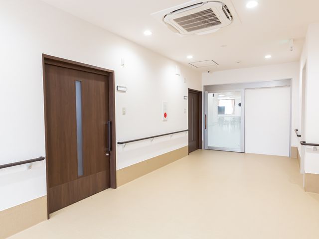 明るく広々とした廊下 廊下 ゆとりある空間の廊下は、移動に便利で安全な手すりが設置されています。明るい照明と清潔感のある壁で、快適な環境が整っています。