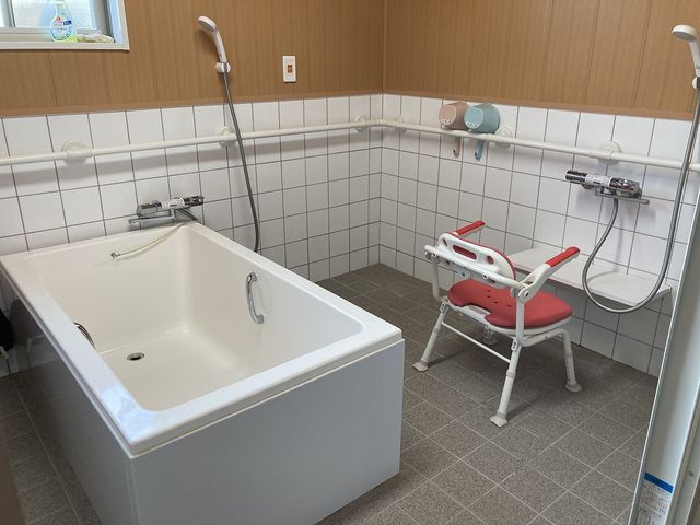 安全に配慮された浴室 浴室   手すり付きのバスタブとシャワーチェアが備わった、入浴をサポートする安全な空間です。