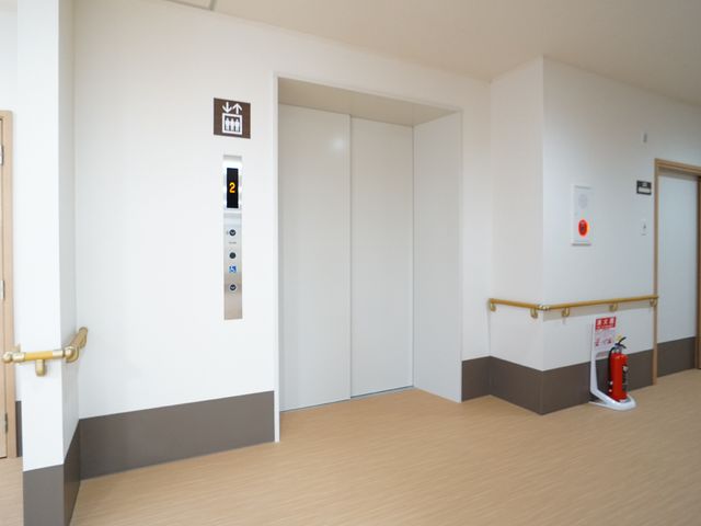 広々とした廊下のエレベーター エレベーター 手すりが取り付けられたきれいな廊下です。ゆったりとしたスペースが確保されており、快適にお過ごしいただけます。