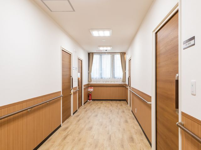 清潔な廊下と部屋の扉 廊下 広々として清潔感のある通路です。手すりが整備され、どなたでも安心して歩けるようになっています。