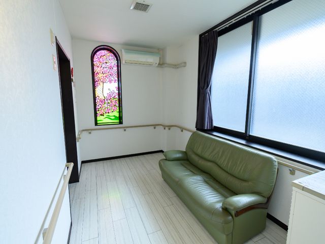 清潔な休憩室の一角 廊下 広々とした休憩室には、くつろげるソファが設置されており、窓からは自然の光がたっぷりと差し込んでいます。