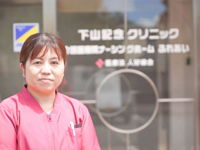 スタッフの様子と看板 看板 施設の看板前で、スタッフが明るく対応しています。訪問者への案内がスムーズです。