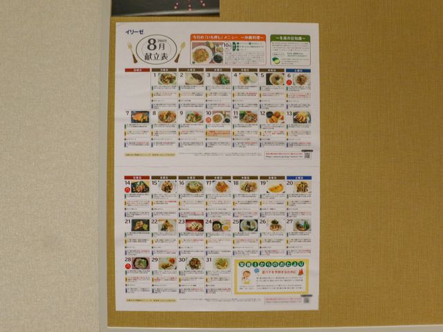 壁掛けの献立表 献立表 毎日の食事メニューが一目でわかる献立表が壁に掲示されています。栄養バランスを考えた豊富なメニューが充実しており、健康管理に役立ちます。