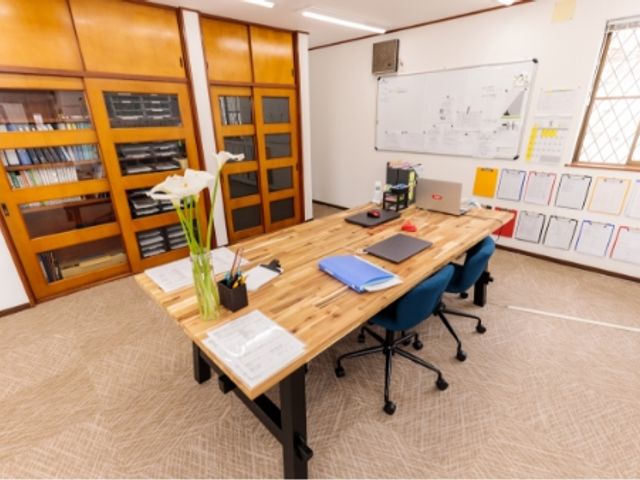 書類と机のある部屋 多目的室 広々とした多目的室で、作業やミーティングに適したスペースです。快適に資料を整理できます。