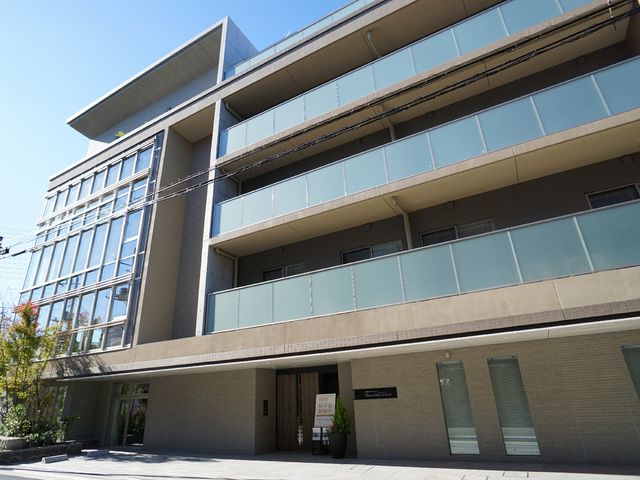 モダンな建物のエントランス 外観 落ち着いた色合いのエントランスは、訪れる方を優しく迎え入れ、働くスタッフへの心地よい第一歩を提供します。