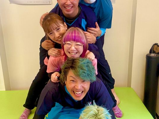 笑顔のスタッフが重なり合う室内  
