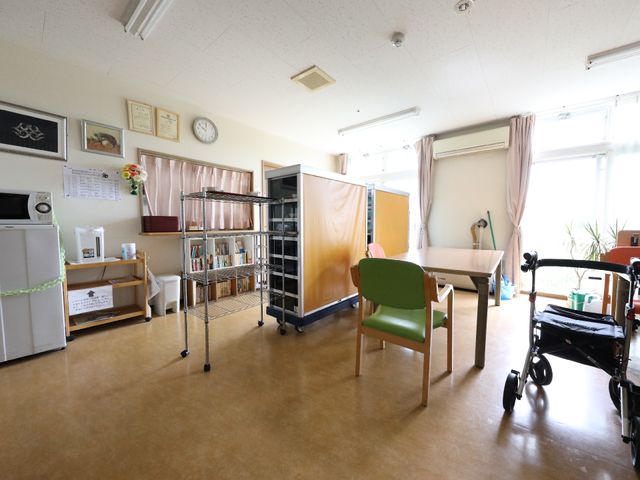 共有スペースの明るい居室 共有スペース この居室は日当たりがよく、温かみのある雰囲気です。読書やくつろぎの時を過ごすには最適な空間となっております。