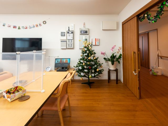 クリスマスツリーのある居室 リビングダイニング 落ち着いた雰囲気の居室で、季節感ある装飾が施された空間です。共有のリビングでのひと時を、心地よく過ごせる設計となっています。