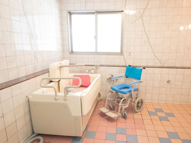 ケア用バス設備と車椅子 浴室 明るく清潔感のある浴室で、高齢者や障がいをお持ちの方も安心してご利用いただけます。利便性を考えたバス設備と車椅子が配備されております。